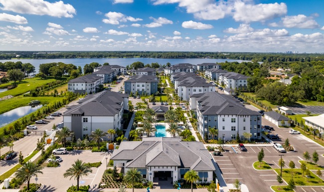 a body of water with buildings and trees around at The Shores at Lake Howell Apartments in Casselberry, FL it